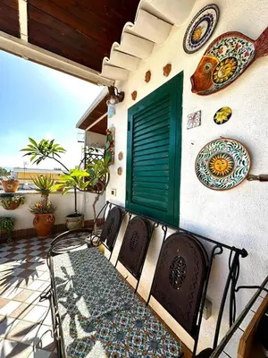 two wicker chairs and a table on a balcony at Casa Lunastella Locazione Turistica in Mondello