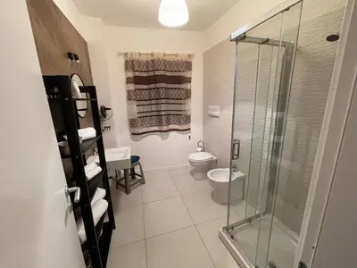 a bathroom with a toilet and a glass shower at 100 PASSI in Palermo