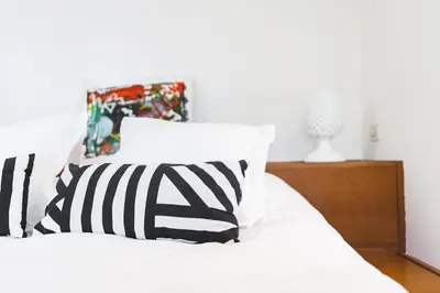 a white bed with black and white pillows at ChiChi Home in Palermo