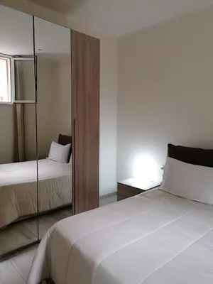 a bedroom with two beds and a mirror at Le Due Pigne - Palermo in Palermo