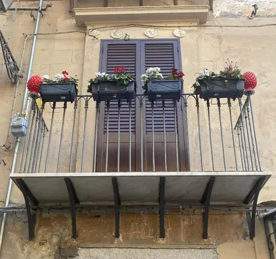 a balcony with three flower boxes on a window at Le Due Pigne - Palermo in Palermo