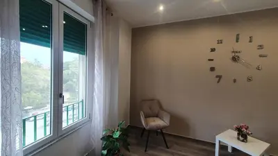 a living room with a chair and a window at Garibaldi Rooms 29 - Piazza Marina a Palermo - In pieno Centro. in Palermo