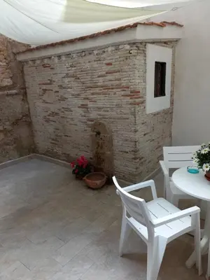 a patio with white chairs and a brick fireplace at Casa Villafilippina in Palermo