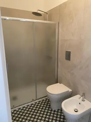 a bathroom with a shower and a toilet and a sink at Il gallo di Eracle - Charming suites & rooms in Termini Imerese