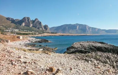 a rocky beach with mountains in the background at MAKARI, Villetta Rocca Pirciata in Macari