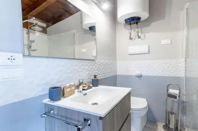 a bathroom with a sink and a toilet and a mirror at Deluxe Sicily Villa in Buonfornello