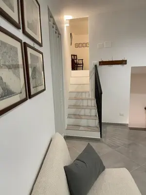a living room with a couch and a staircase at Cathedral House Design in Palermo