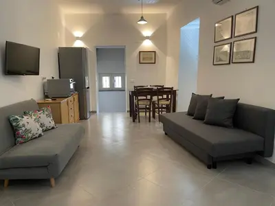 a living room with two couches and a dining room at Cathedral House Design in Palermo