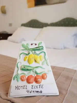 a cake with fruit on it sitting on a table at Hotel Elite Palermo Centro in Palermo