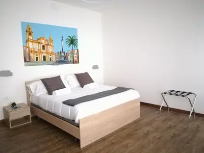a bedroom with a bed and a painting on the wall at Hotel Elite Palermo Centro in Palermo