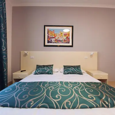 a bedroom with a large bed with two pillows at Hotel Centrale Spa & Relax in Alcamo