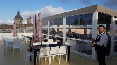 a man standing on a balcony with a table and chairs at Hotel Centrale Spa & Relax in Alcamo