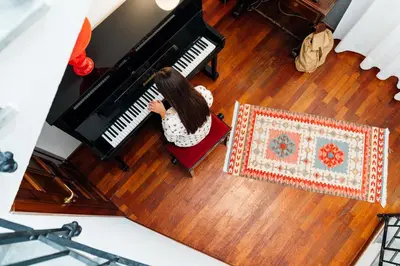 a young girl sitting in a red chair playing a piano at Hotel Ambasciatori in Palermo