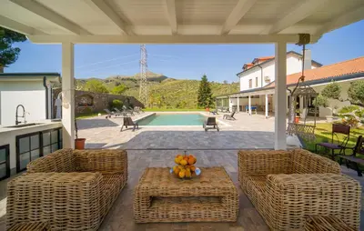 a patio with two chairs and a table with fruit on it at Dimora Di Famiglia in Belmonte Mezzagno