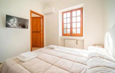 a bedroom with a large white bed with a window at Dimora Di Famiglia in Belmonte Mezzagno
