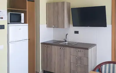 a small kitchen with a sink and a refrigerator at Mono 2 in Lido di Mondello