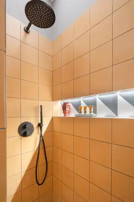 a shower in a bathroom with orange tiles at Vossia Luxury Rooms & Sicilian Living in Palermo
