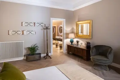 a living room with a chair and a mirror at Vossia Luxury Rooms & Sicilian Living in Palermo