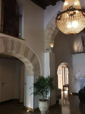 a room with a potted plant and a chandelier at Ucciardhome Hotel in Palermo