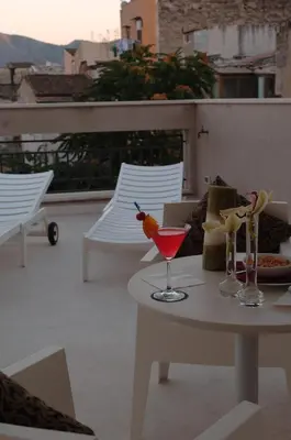 a table with a drink on top of a balcony at Ucciardhome Hotel in Palermo