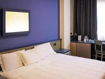 a bedroom with a large bed with a purple wall at President Hotel Palermo in Palermo