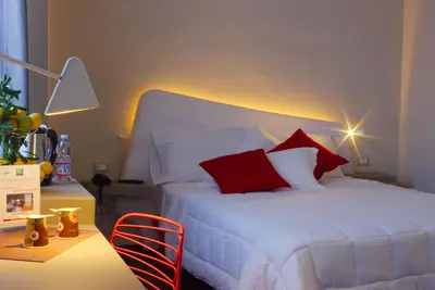 a bedroom with a white bed with red pillows at President Hotel Palermo in Palermo