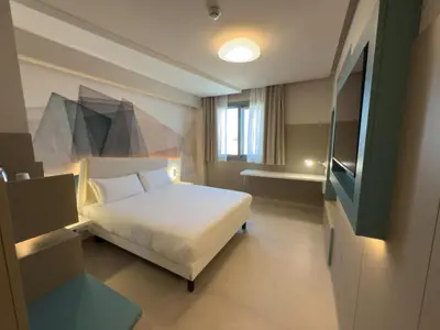 a hotel room with a bed and a television at President Hotel Palermo in Palermo