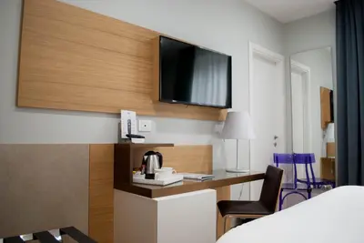 a hotel room with a bed and a tv on the wall at Best Western Ai Cavalieri Hotel in Palermo