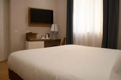 a bedroom with a white bed and a television at Best Western Ai Cavalieri Hotel in Palermo
