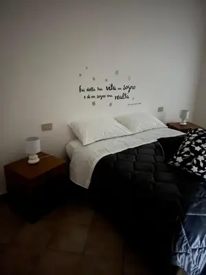 a bedroom with a bed with writing on the wall at House Corso Calatafimi in Palermo