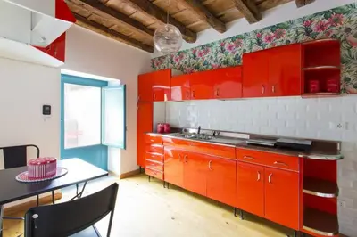 a kitchen with red cabinets and a table in it at Casa del Vinile in Palermo
