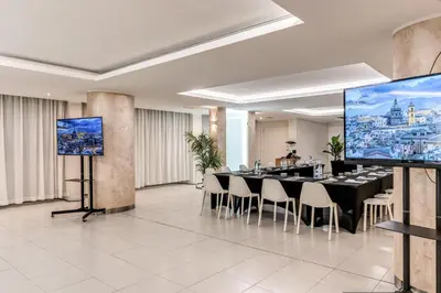 a conference room with a long table with chairs and screens at Casena Dei Colli, Sure Hotel Collection By Best Western in Palermo
