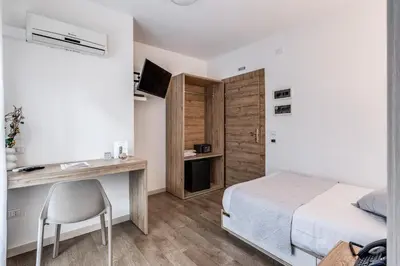 a bedroom with a bed and a desk with a computer at Casena Dei Colli, Sure Hotel Collection By Best Western in Palermo