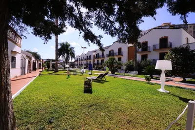 a park with benches and a lamp in the grass at Casena Dei Colli, Sure Hotel Collection By Best Western in Palermo