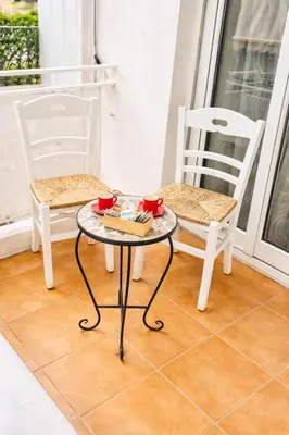 two chairs and a table with a potted plant on a balcony at La casa di Angy in Terrasini