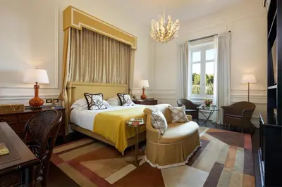a hotel room with a bed and a chair at Rocco Forte Villa Igiea in Palermo