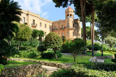 a large building with a tower on top of it at Rocco Forte Villa Igiea in Palermo