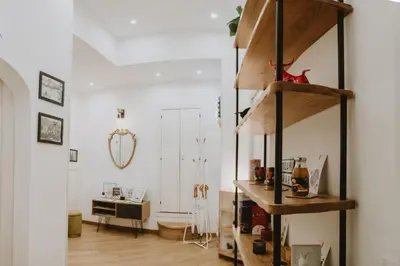 a living room with wooden shelves and a desk at Maravigghia Palermo Rooms in Palermo