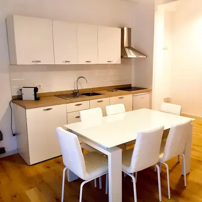 a kitchen with a white table and white chairs at Residence D'azeglio in Palermo