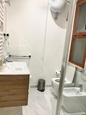 a white bathroom with a toilet and a sink at Residence D'azeglio in Palermo