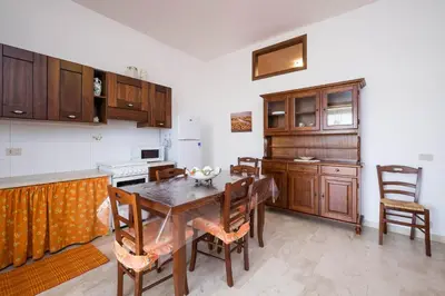 a kitchen with a table and chairs in a room at RESIDENCE FEDERICA in Castellammare del Golfo