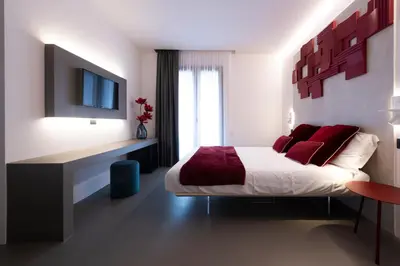 a bedroom with a bed with red pillows and a television at Civic03 B&B in Terrasini