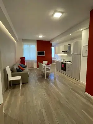 a living room with a couch and a table and a kitchen at Wagner House in Palermo