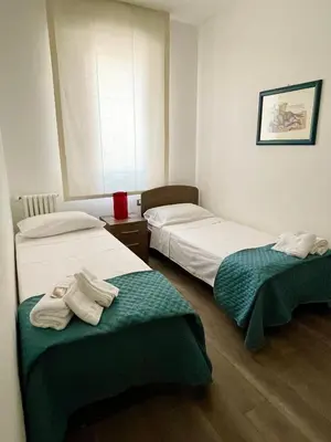 two beds in a room with towels on them at Wagner House in Palermo