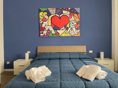 a blue bedroom with a heart painting on the wall at Wagner House in Palermo