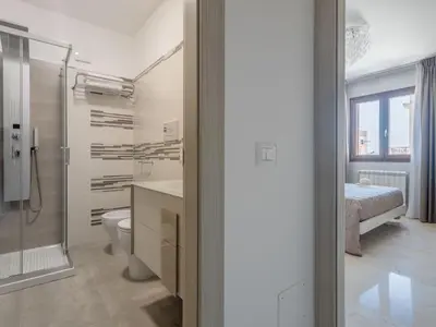 a bathroom with a shower and a toilet and a bed at Apartment Palermo by Interhome in Balestrate