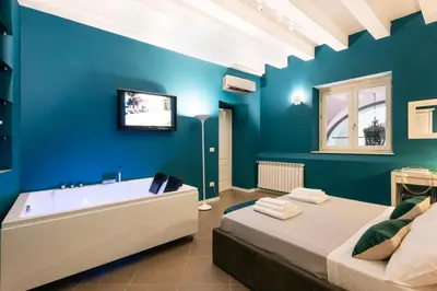 a blue bathroom with two beds and a bathtub at Carlo Suite Apartments con Vasca Idromassaggio in Palermo
