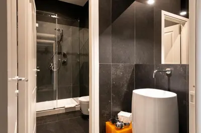 a bathroom with a shower and a toilet and a sink at Carlo Suite Apartments con Vasca Idromassaggio in Palermo