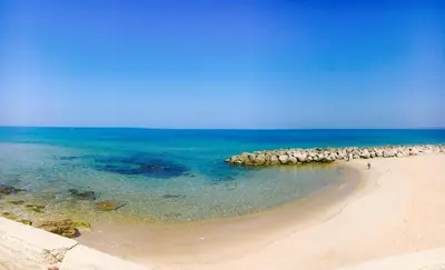 a beach with a group of rocks in the water at A-marè - CasaVacanza in Trappeto