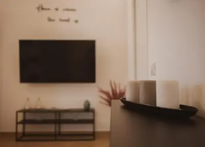 a living room with a tv and a table at Agorà Home in Terrasini